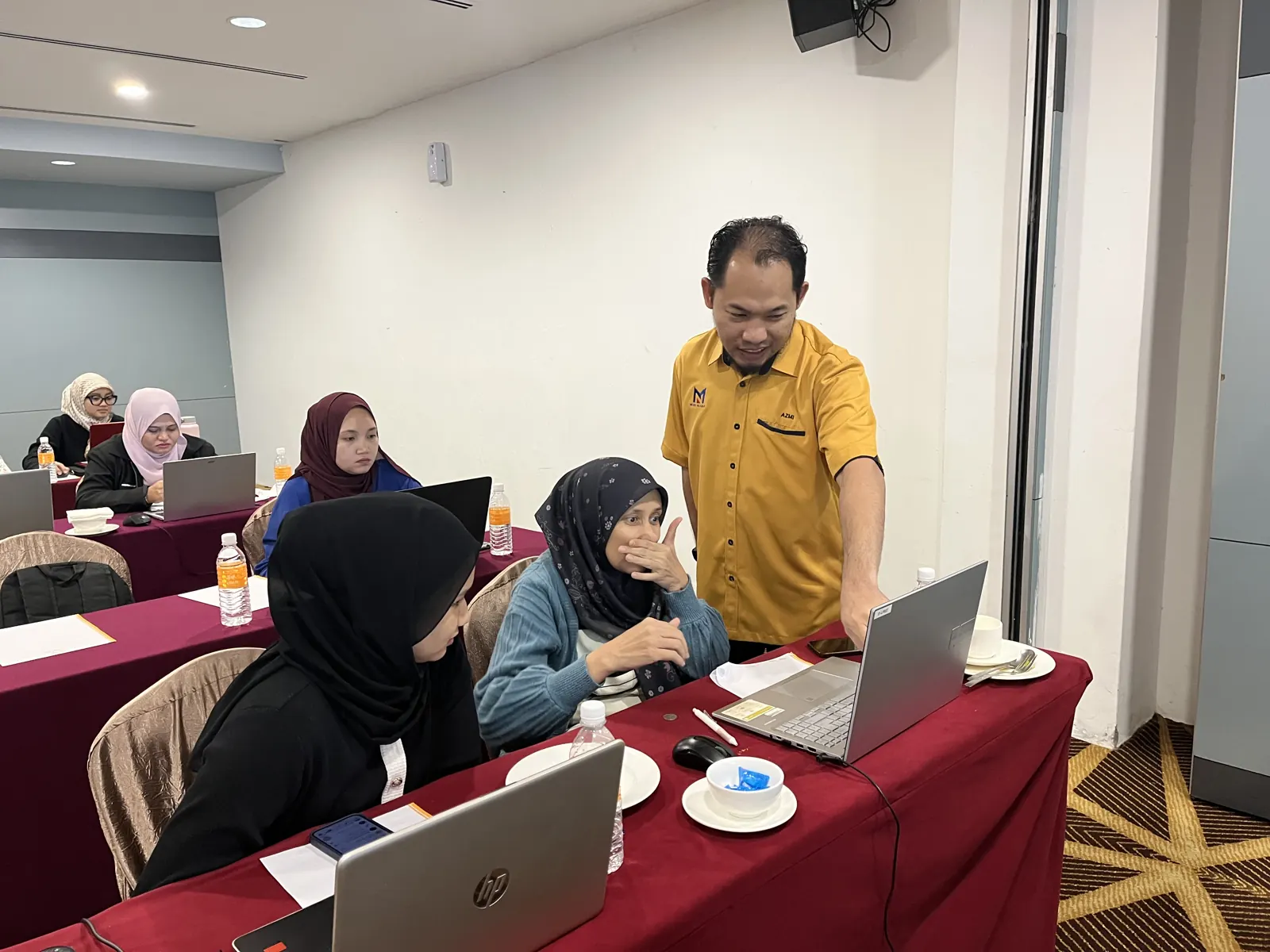Membantu peserta menyiapkan tugasan hiring di laptop