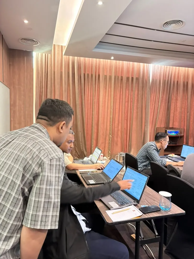 Membantu peserta menyelesaikan tugasan di laptop